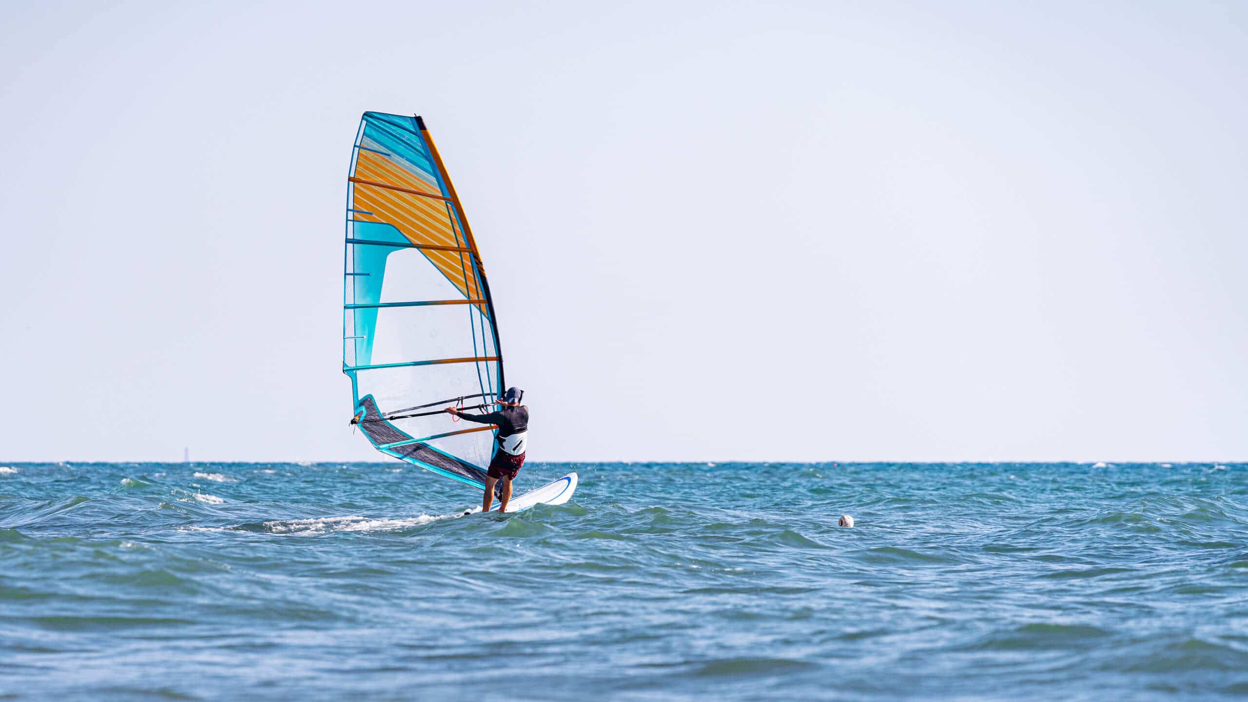 A man controls a sailboard at sea, on a greek superyacht charter