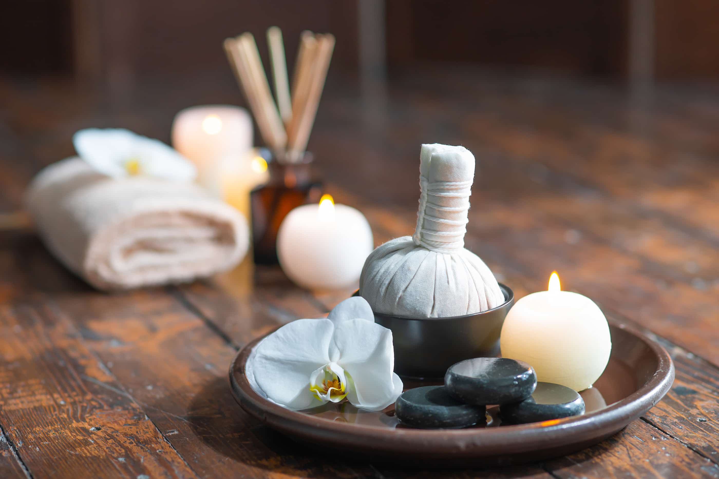 Spa background. Towel, candles, flowers, aroma sticks, massaging stones and herbal balls. Massage, oriental therapy, wellbeing and meditation. superyacht charter