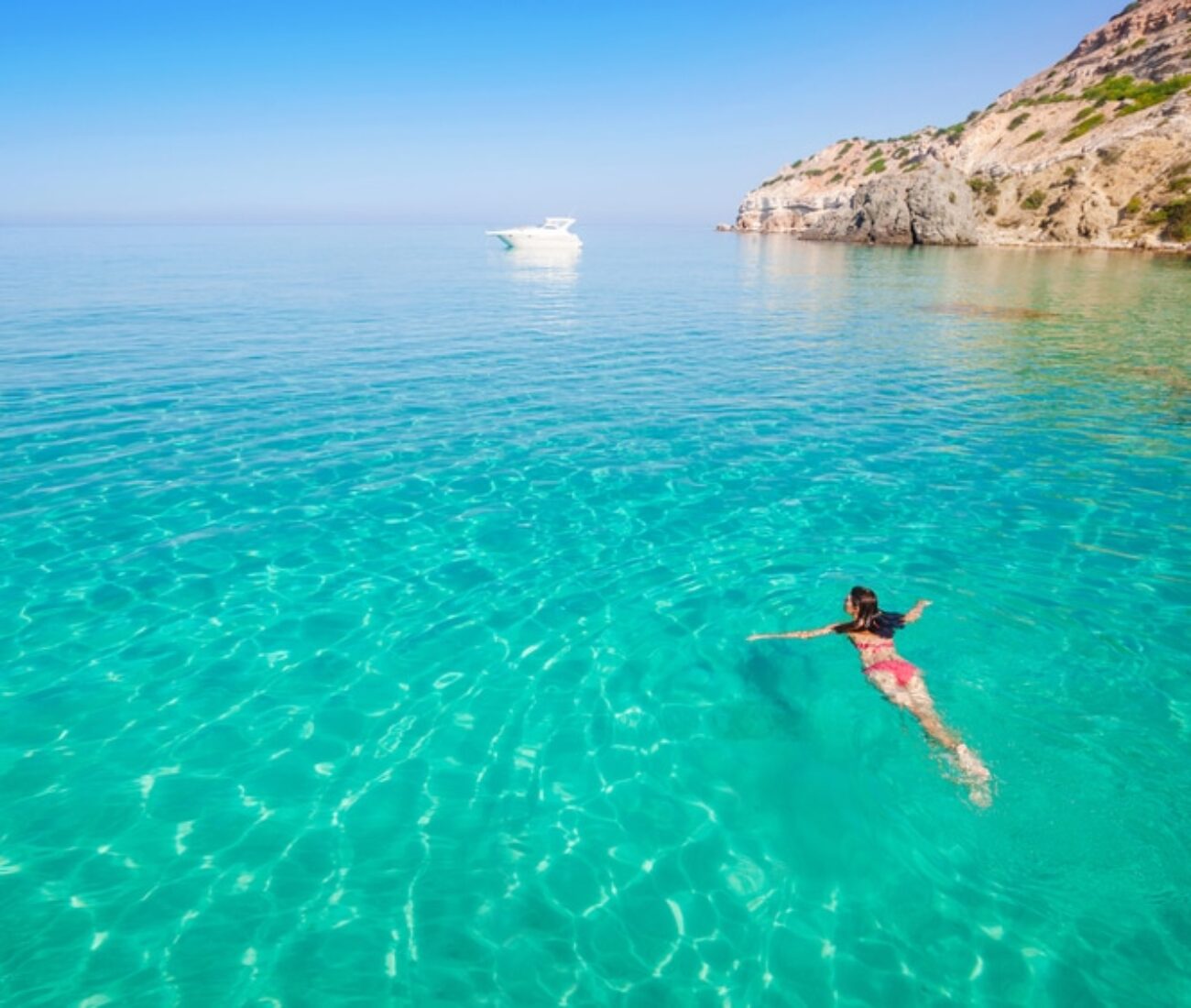 woman swimming in the seychelles turquoise water